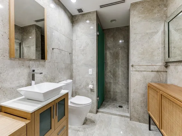 a bathroom with a sink a toilet and shower