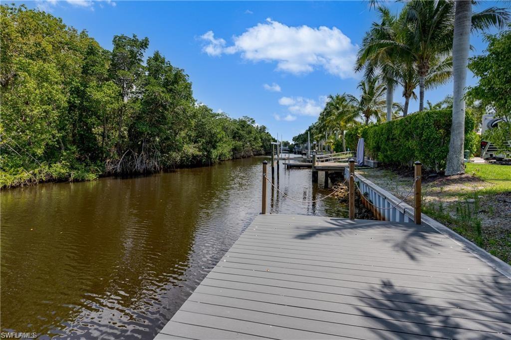 13375 Snook Circle Naples, FL 34114 - Photo 5 of 28 a view of a lake with a table and chairs