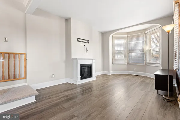 a view of empty room with wooden floor and fireplace