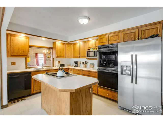 a kitchen with stainless steel appliances kitchen island granite countertop a stove and a sink