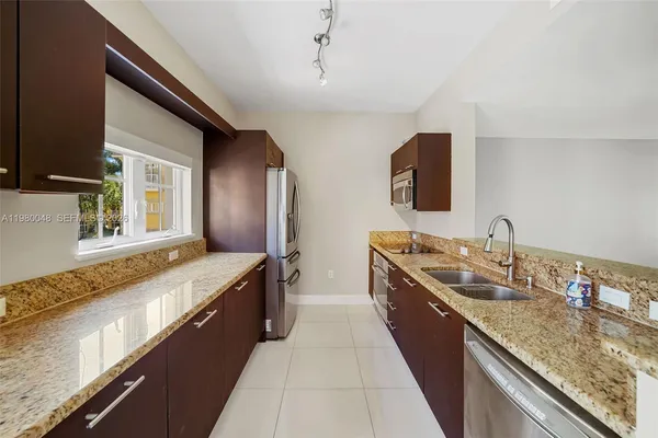 a large kitchen with kitchen island granite countertop a sink and a stove