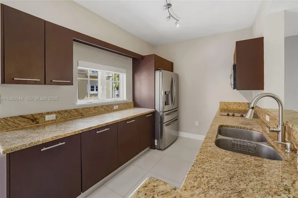 a kitchen with stainless steel appliances granite countertop a sink a stove and a refrigerator