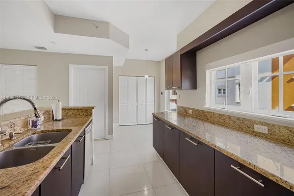 a kitchen with granite countertop a sink and a stove