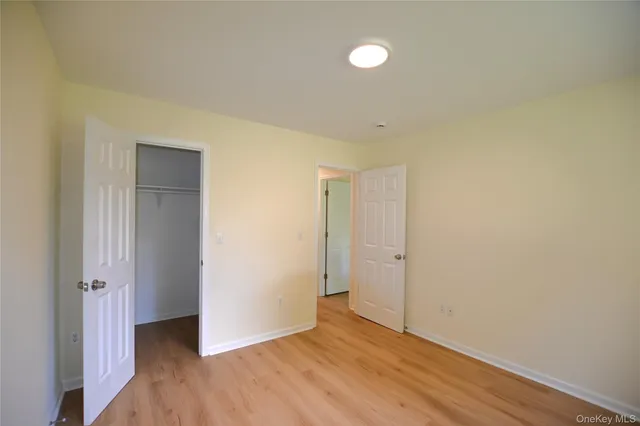 an empty room with wooden floor and closet