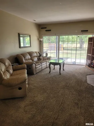 a living room with furniture and large windows