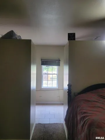 a bed sitting in a bedroom next to a window