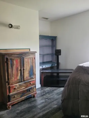 a bedroom with furniture and wooden floor