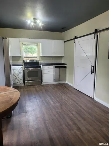 a kitchen with granite countertop white cabinets and stainless steel appliances