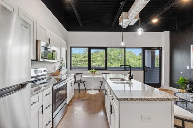 a kitchen with stainless steel appliances granite countertop a stove a sink and a refrigerator