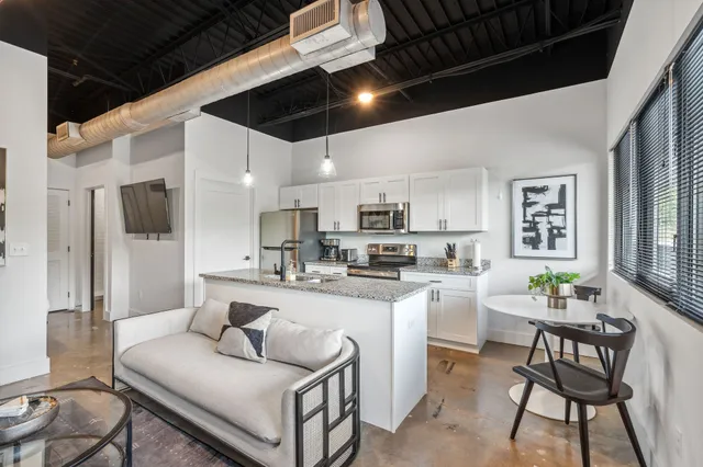 a living room with stainless steel appliances kitchen island granite countertop furniture and a kitchen view