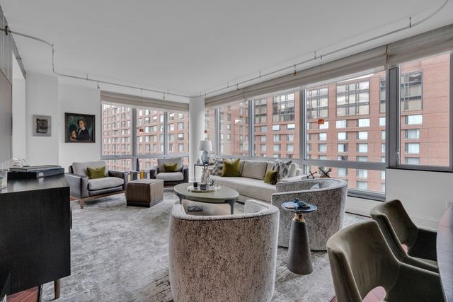 a living room with furniture and large windows