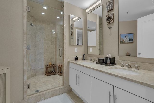 a bathroom with a granite countertop sink mirror and shower