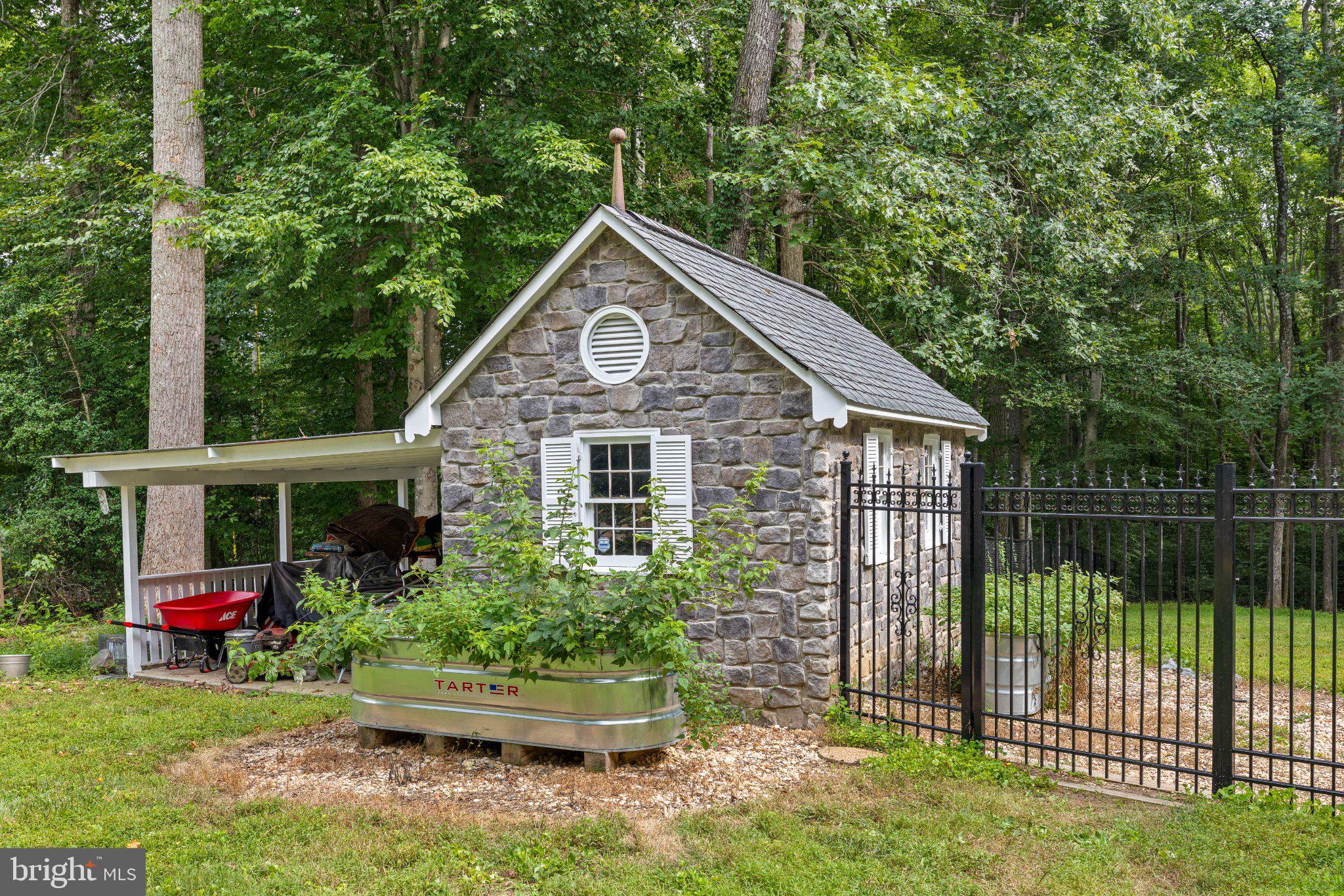 10707 Gordon Road Spotsylvania, VA 22553 - Photo 2 of 23 Charming stone shed in lush greenery.