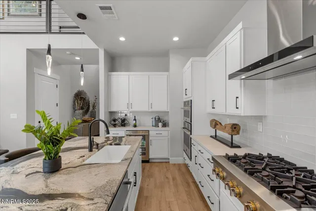 a kitchen with stainless steel appliances kitchen island granite countertop a sink a stove and cabinets