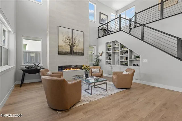 a living room with couches a fireplace and cabinet with wooden floor