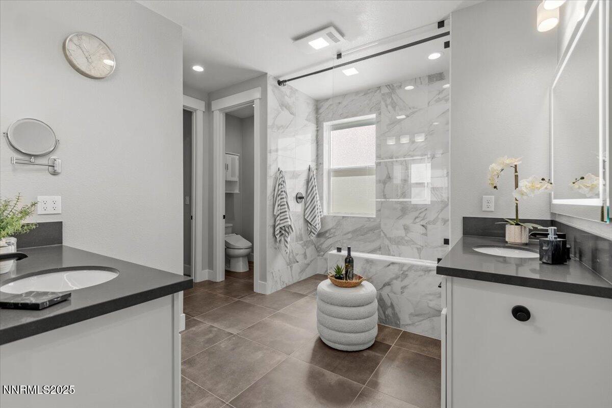 5517 Western Rider Trail Reno, NV 89511 - Photo 22 of 49 a bathroom with a granite countertop sink a toilet and a mirror