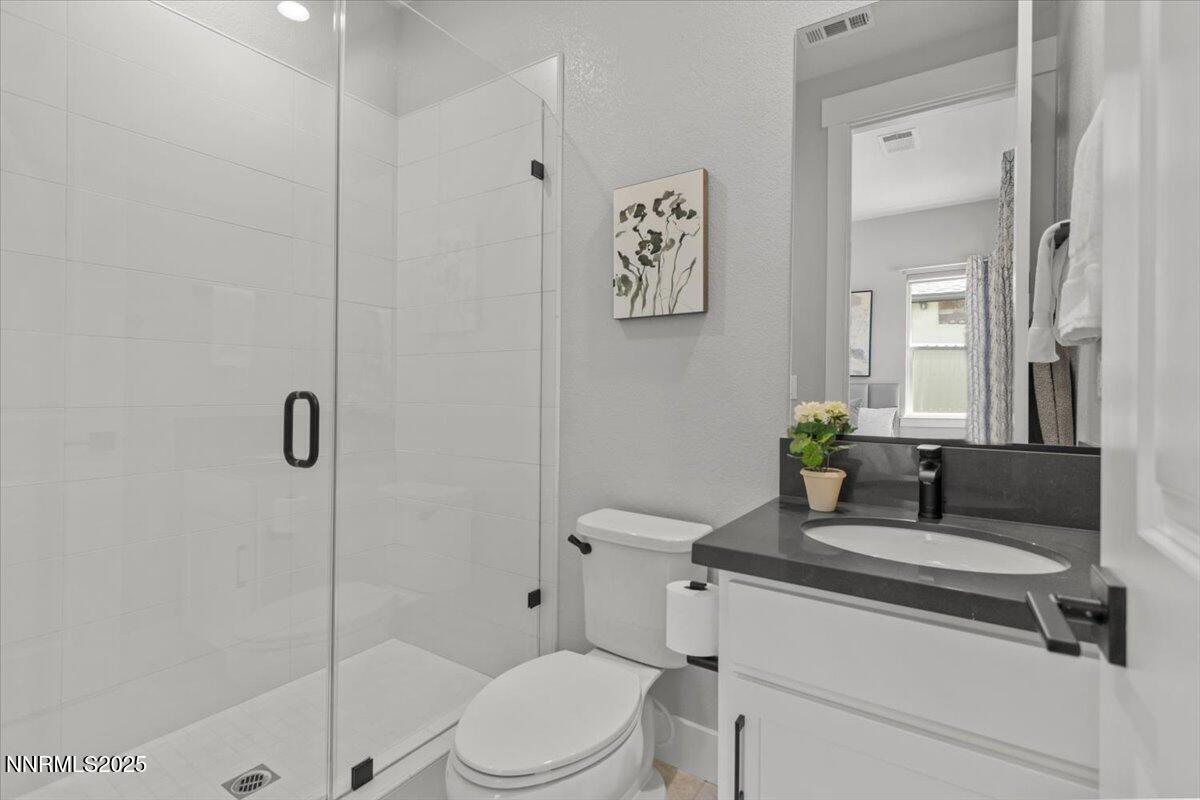 5517 Western Rider Trail Reno, NV 89511 - Photo 29 of 49 a bathroom with a granite countertop toilet sink and shower