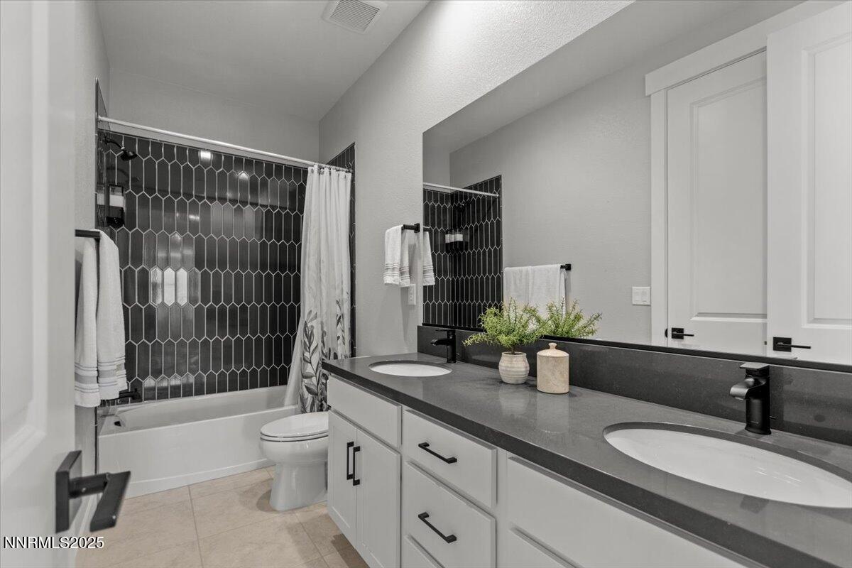 5517 Western Rider Trail Reno, NV 89511 - Photo 36 of 49 a bathroom with a granite countertop sink a toilet a mirror and shower