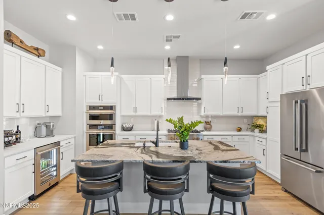 a kitchen with refrigerator a sink and chairs