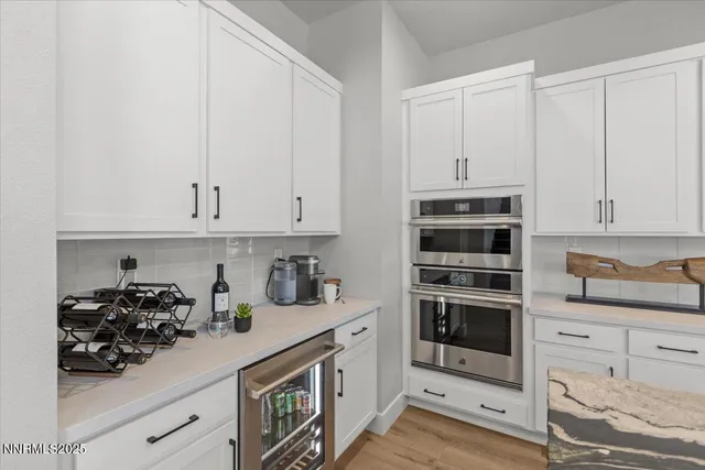 a kitchen with white cabinets and appliances