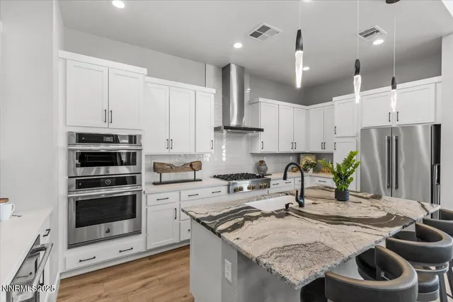 a kitchen with stainless steel appliances granite countertop a stove a sink a refrigerator and a refrigerator