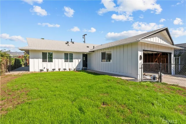 a view of a house with backyard and sitting area