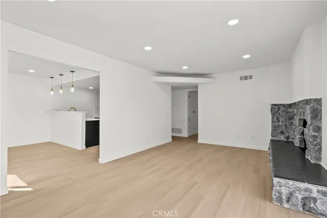 an empty room with floor to ceiling window and fireplace