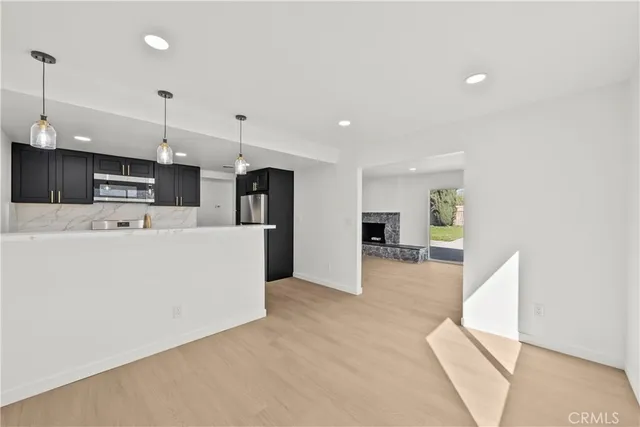 a kitchen with granite countertop a stove and a refrigerator with wooden cabinets