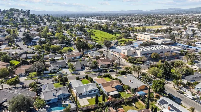 an aerial view of residential house with parking and trees