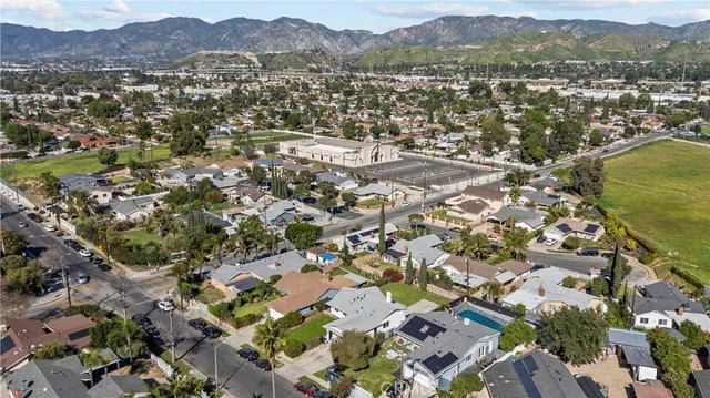 an aerial view of residential house with parking and trees