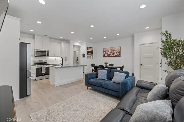 a kitchen with stainless steel appliances granite countertop a refrigerator a stove and a wooden floors