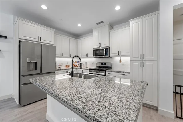 a kitchen with stainless steel appliances granite countertop a sink stove and refrigerator