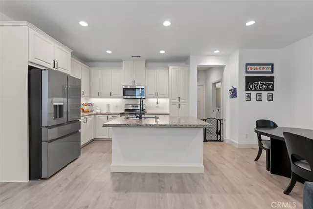 a kitchen with stainless steel appliances granite countertop a refrigerator stove and sink