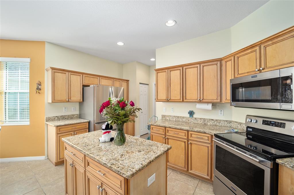 7947 South W 83rd Place Ocala, FL 34476 - Photo 23 of 28 a kitchen with stainless steel appliances granite countertop a sink stove and refrigerator
