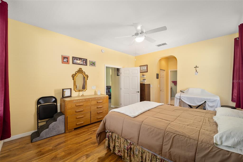 7947 South W 83rd Place Ocala, FL 34476 - Photo 26 of 28 a bedroom with a bed and a chandelier