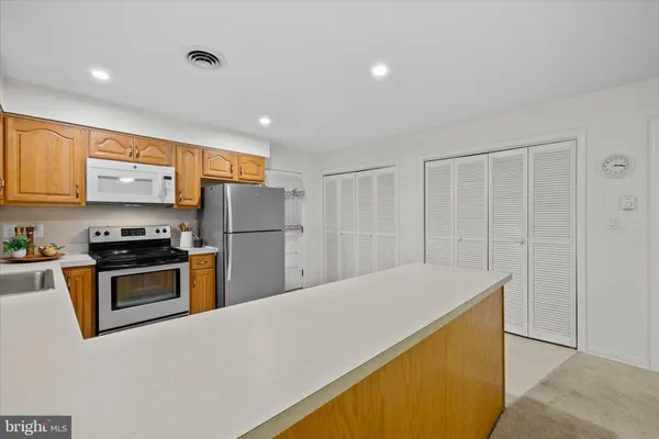 a kitchen with stainless steel appliances granite countertop a refrigerator a stove and a sink with wooden floor