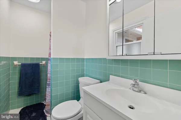a bathroom with a sink mirror and toilet