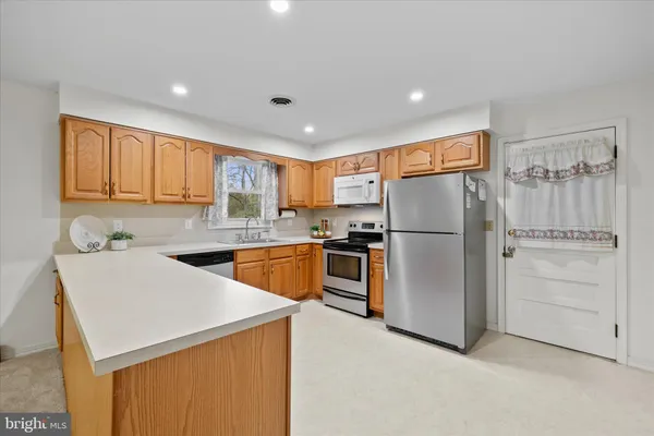 a kitchen with refrigerator cabinets and wooden floor
