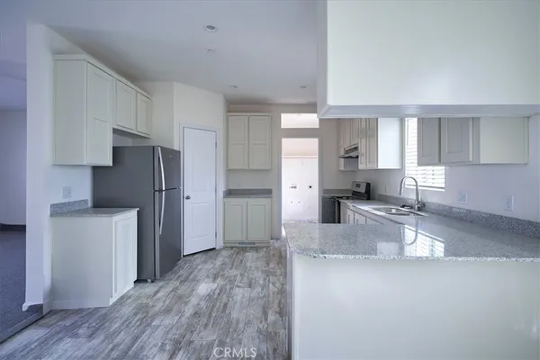 a kitchen with stainless steel appliances granite countertop a stove a sink and a microwave