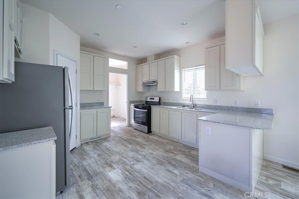 11475 Descanso Road Pinon Hills, CA 92372 - Photo 10 of 35 a kitchen with granite countertop white cabinets and stainless steel appliances