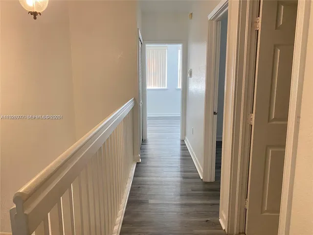 a view of a hallway with wooden floor