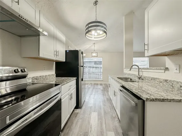 a kitchen with a stove cabinets and a wooden floor