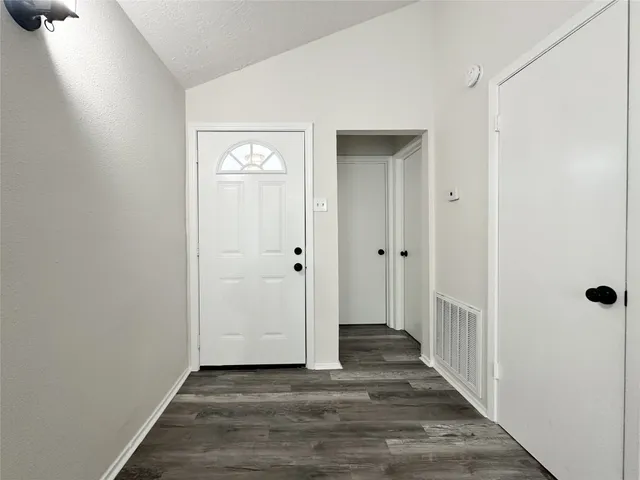 a view of an empty room with a fireplace and a window