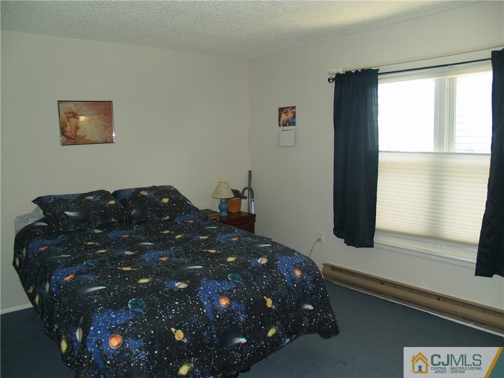 504 A Belford Road, Unit A Monroe Township, NJ 08831 - Photo 28 of 42 a large bed sitting in a bedroom next to a window