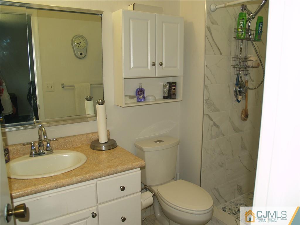 504 A Belford Road, Unit A Monroe Township, NJ 08831 - Photo 33 of 42 a bathroom with a granite countertop sink toilet and shower
