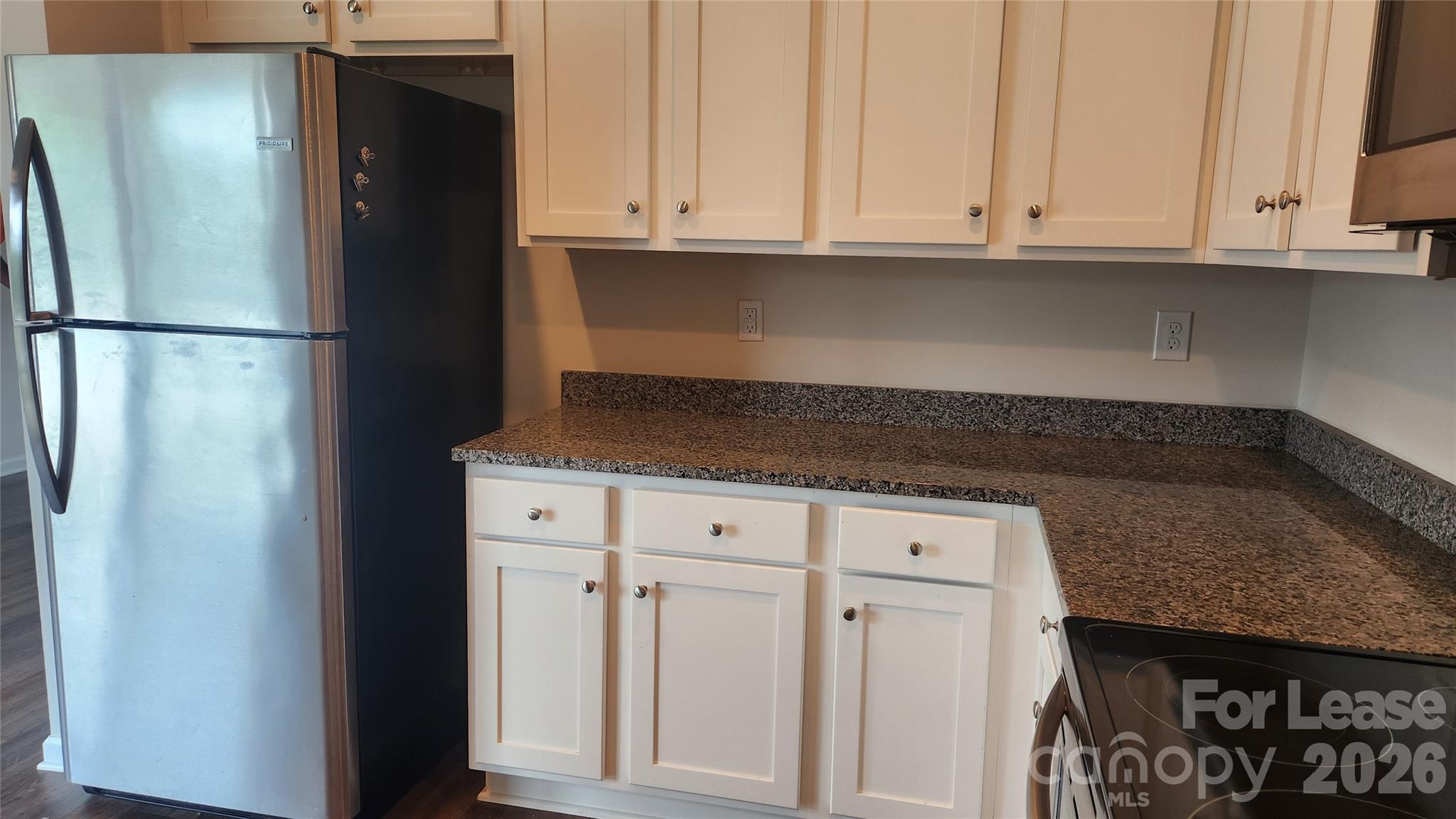 14320 Moss Road Charlotte, NC 28273 - Photo 7 of 22 a kitchen with granite countertop white cabinets and refrigerator