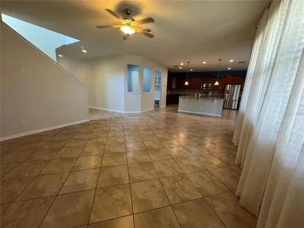 a view of kitchen with stainless steel appliances kitchen island granite countertop a refrigerator and a stove top oven