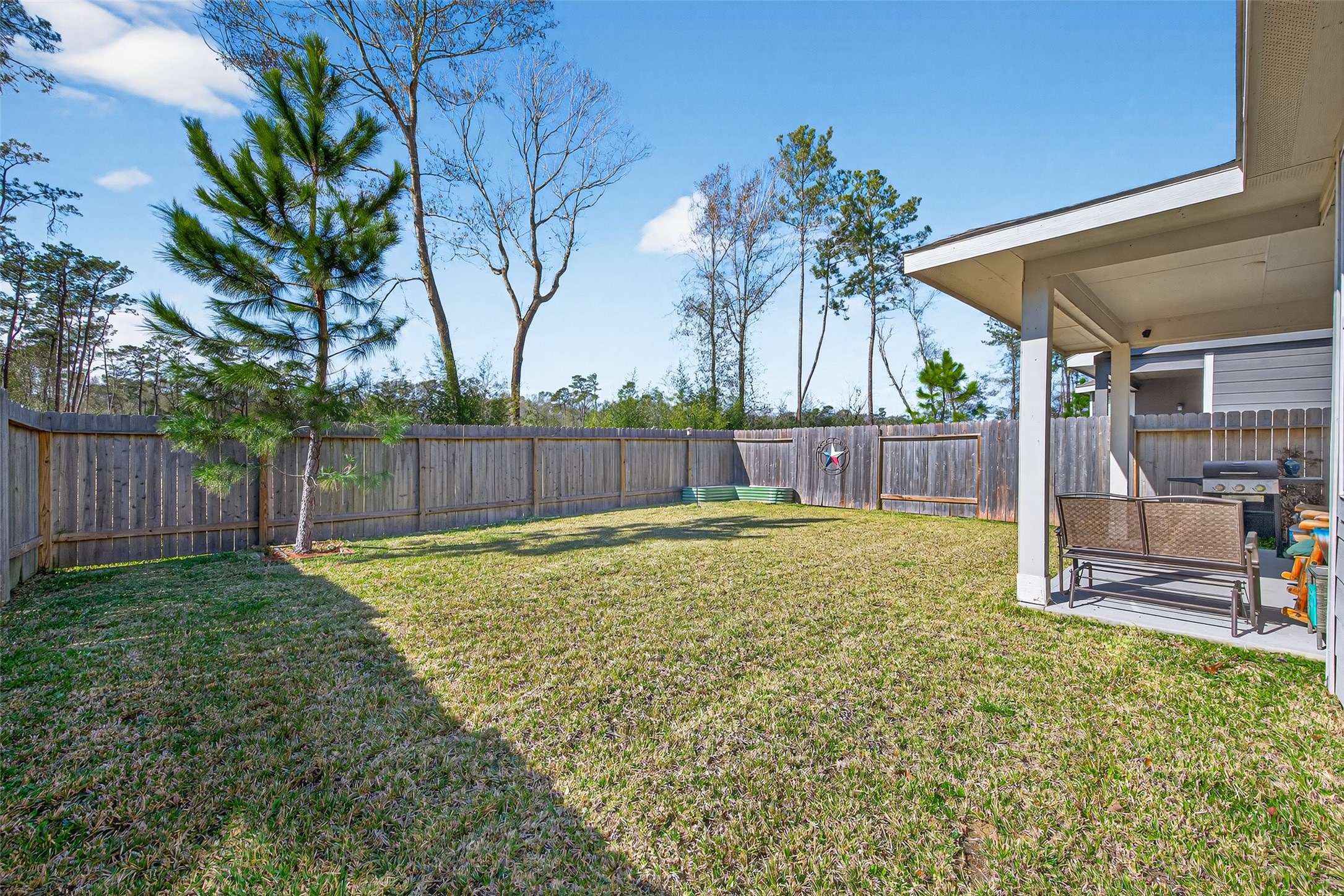 2354 Raider Drive Conroe, TX 77301 - Photo 18 of 20 a view of a backyard with table and chairs and wooden fence