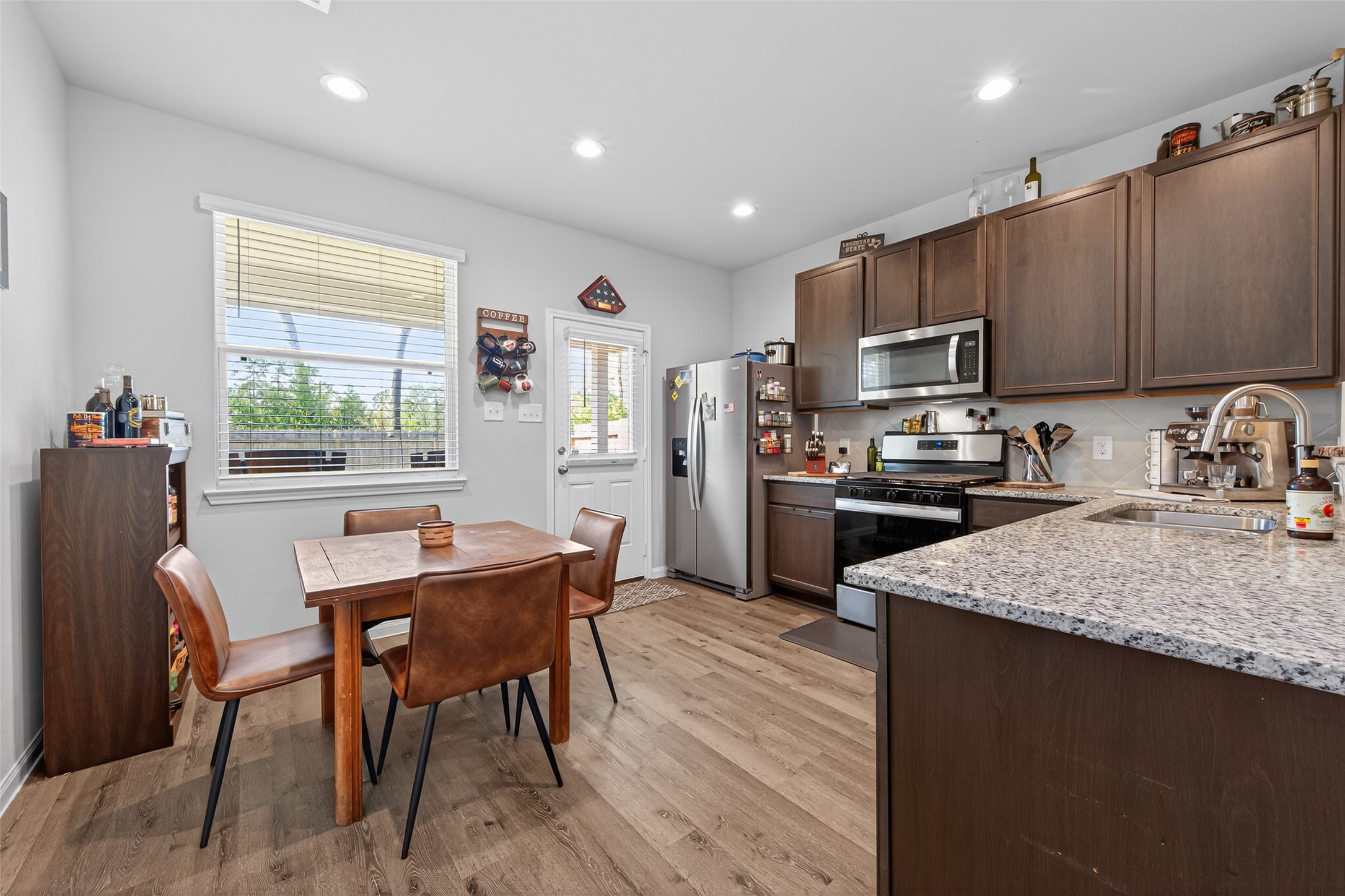 2354 Raider Drive Conroe, TX 77301 - Photo 4 of 20 a kitchen with a table chairs microwave and refrigerator