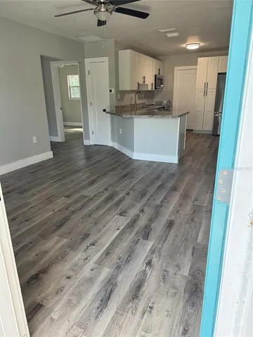 a open kitchen with a sink dishwasher a refrigerator and a fireplace with wooden floor
